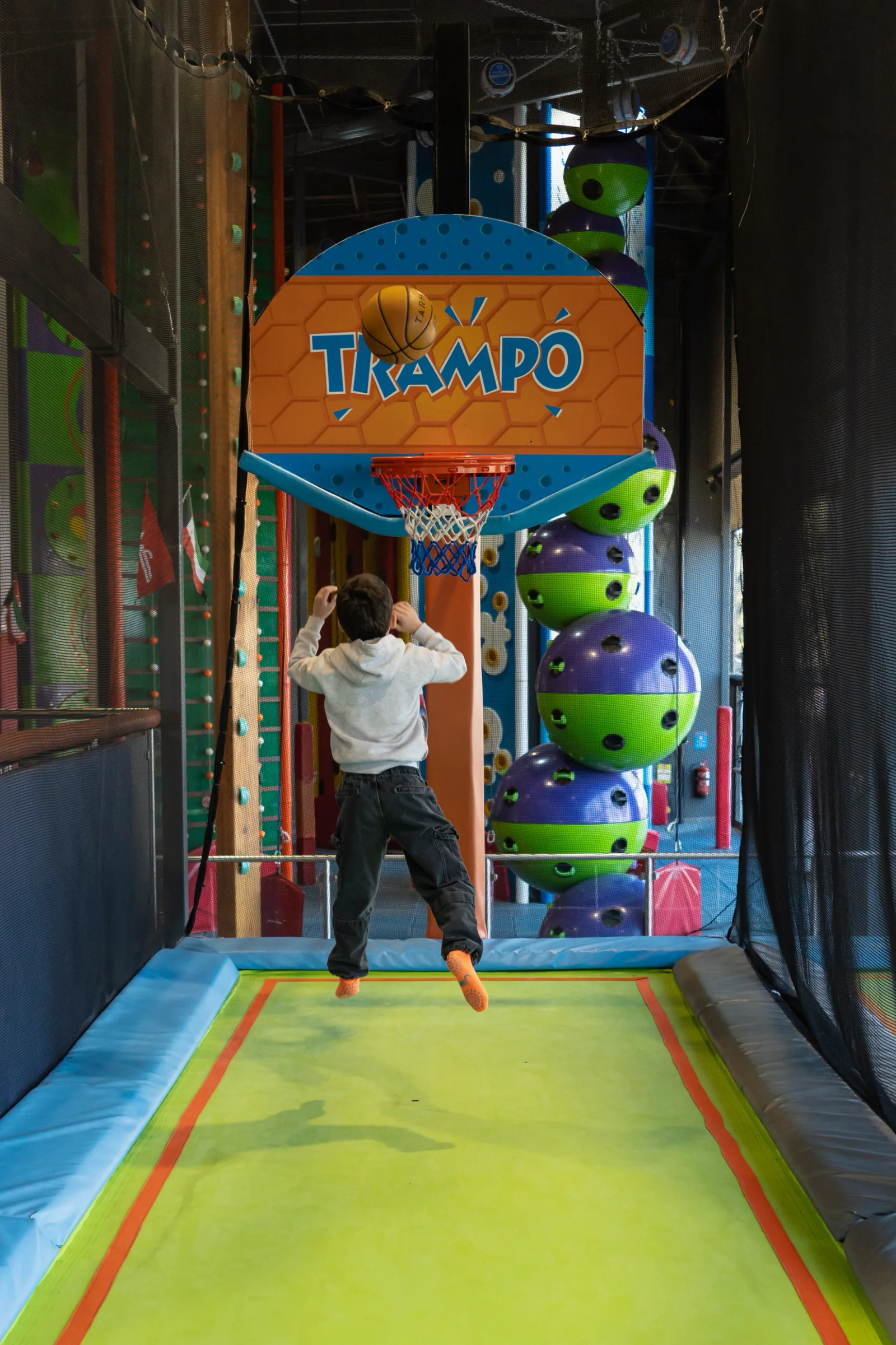 Kid dunking on the orange Trampo basketball hoop at Trampo Kuwait
