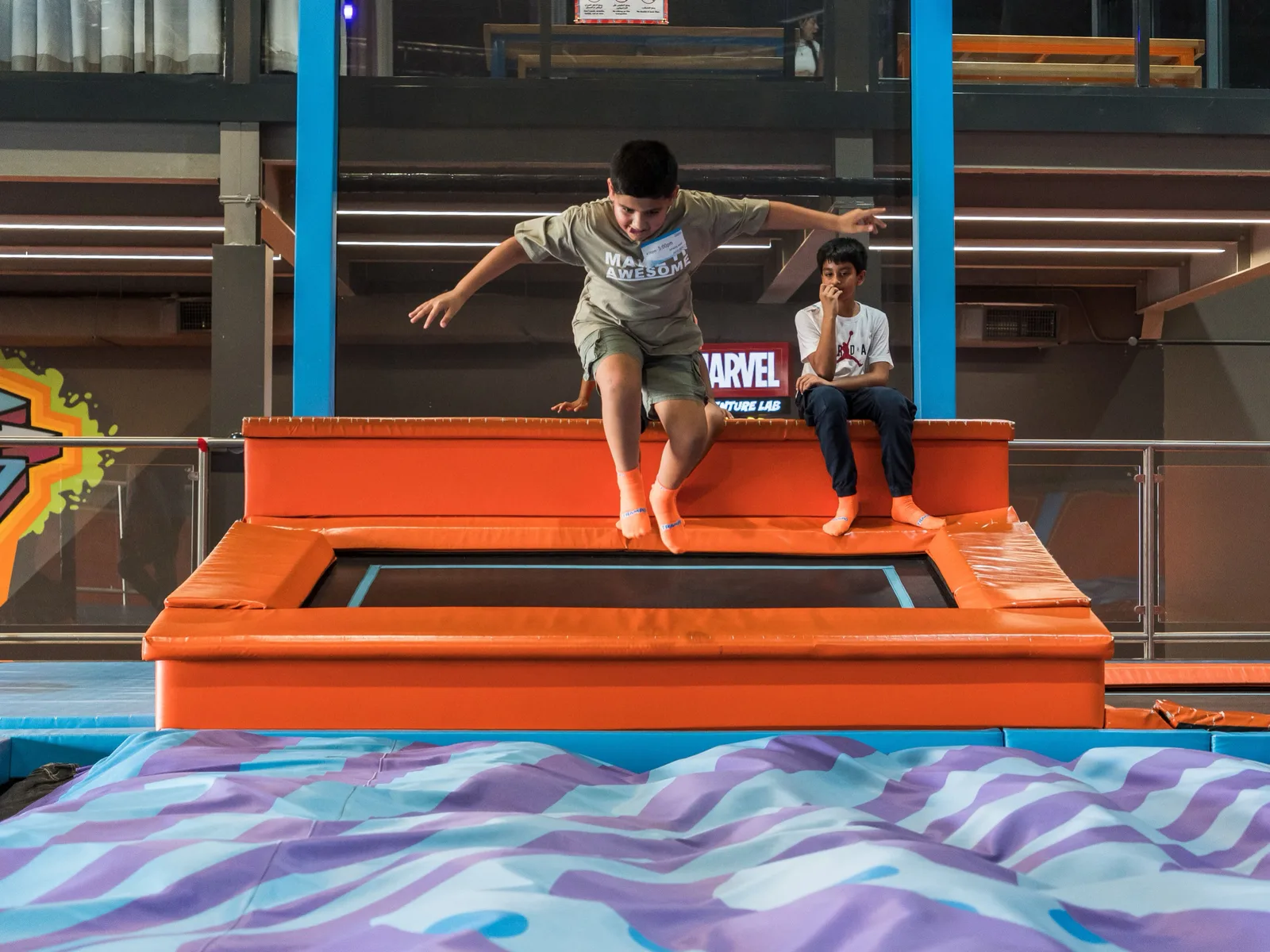 Boy mid-leap launching from the takeoff trampoline toward the BigAirBag