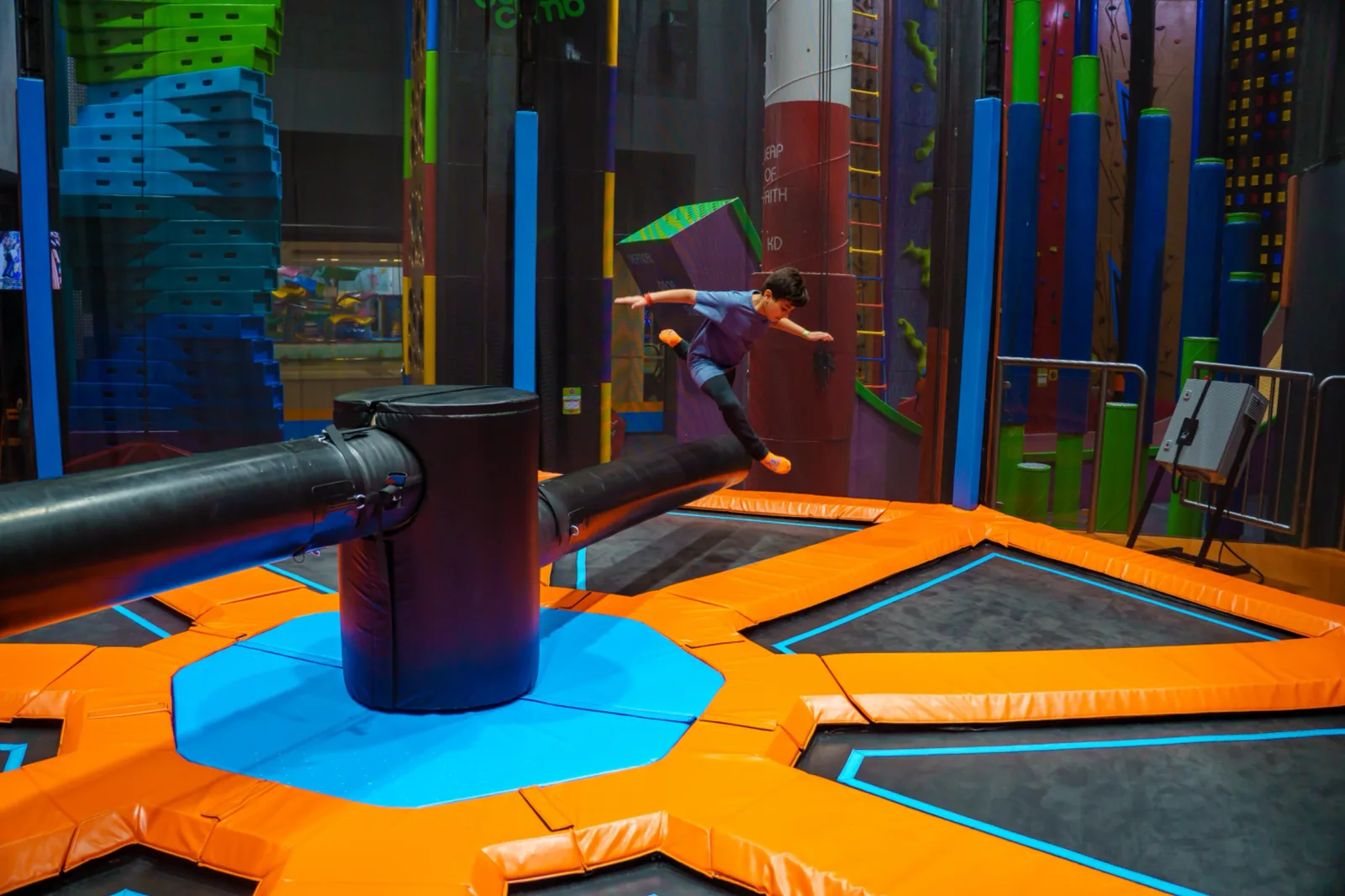 Action shot of the rotating sweeper arm spinning across the circular trampoline floor