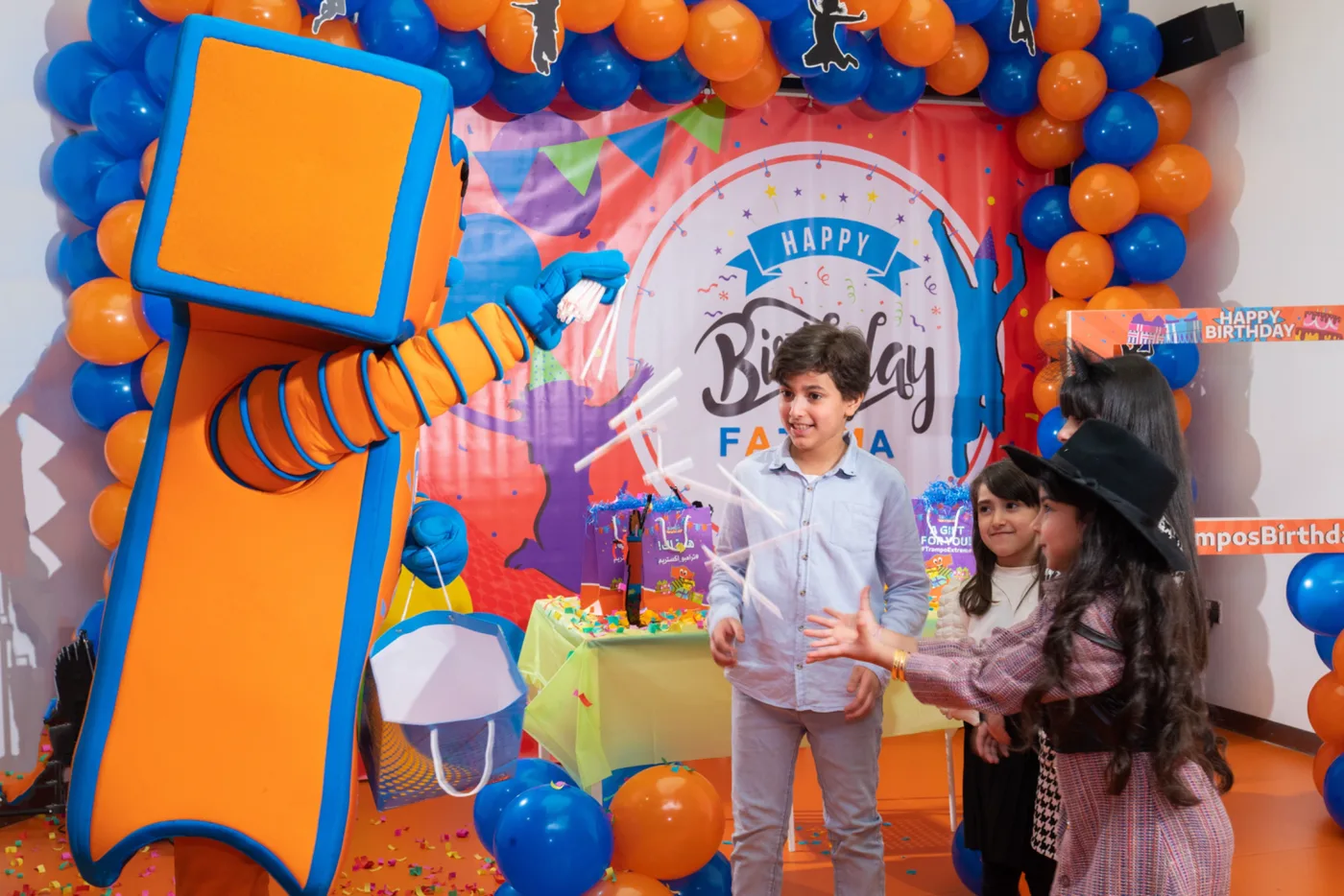 Kids receiving party favours from the Trampo mascot