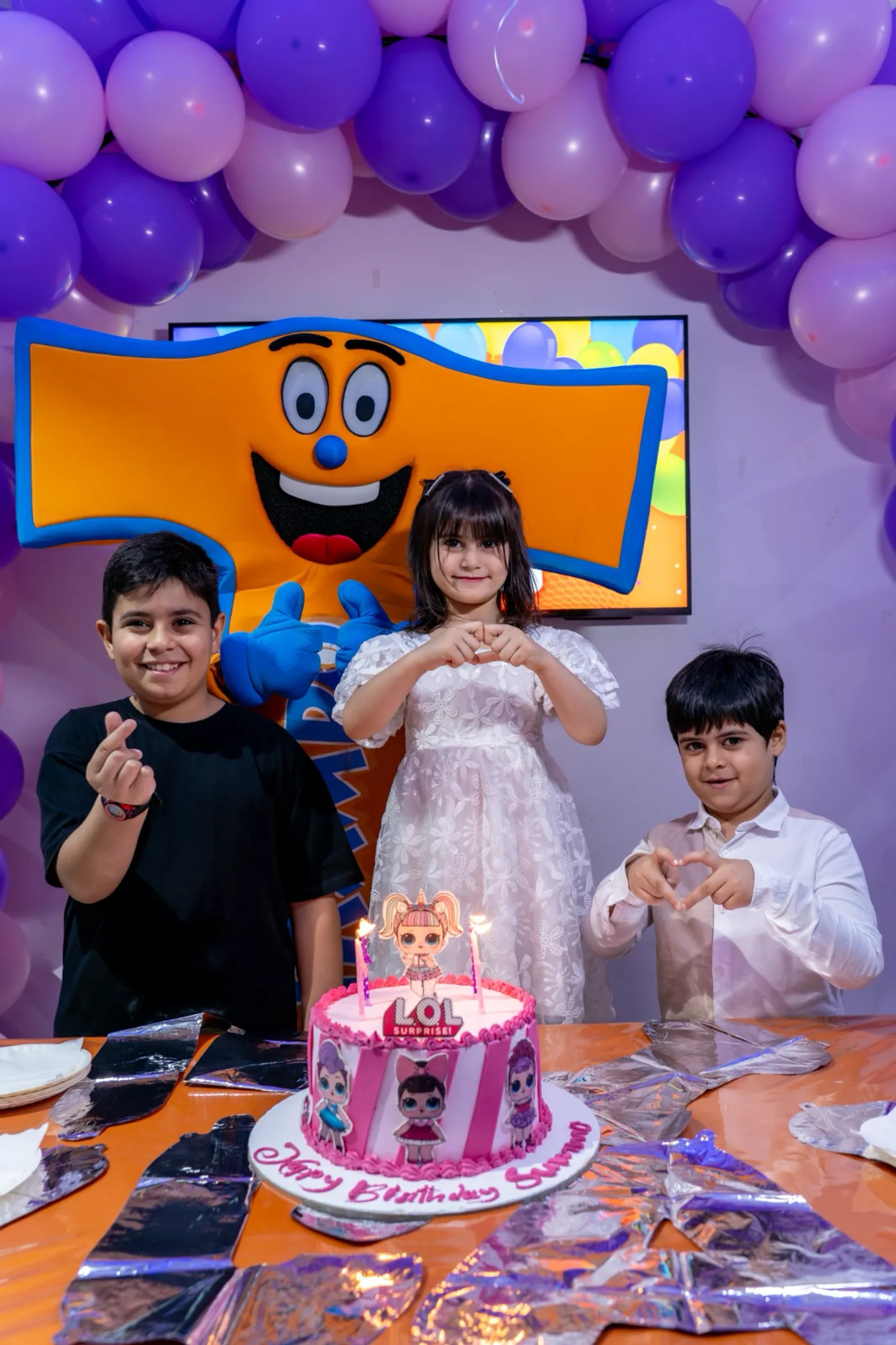 Birthday kids posing with a themed cake